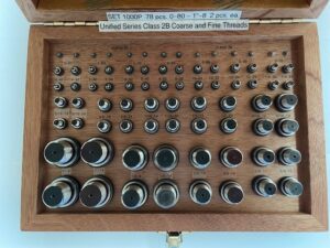 A wooden case filled with metal objects.